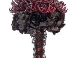 a predator-looking Halloween wedding bouquet of black and burgundy blooms, privet berries, with a red and black wrap