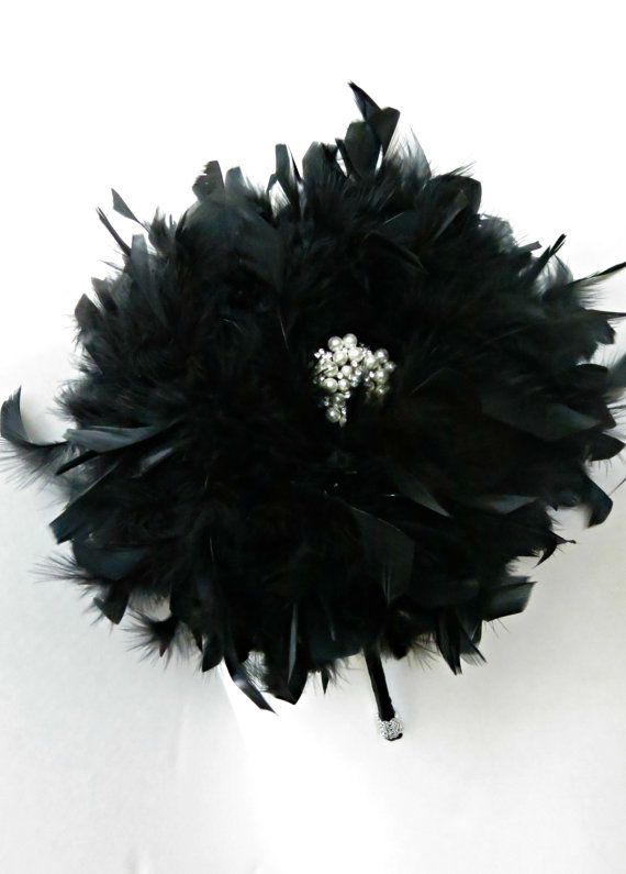 a glam black feather bouquet with an embellishment in the center is a refined and chic idea of a Halloween wedding bouquet
