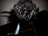 a fantastic black brooch wedding bouquet with feathers is a bold statement for a Halloween bride