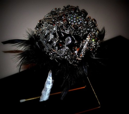 a fantastic black brooch wedding bouquet with feathers is a bold statement for a Halloween bride