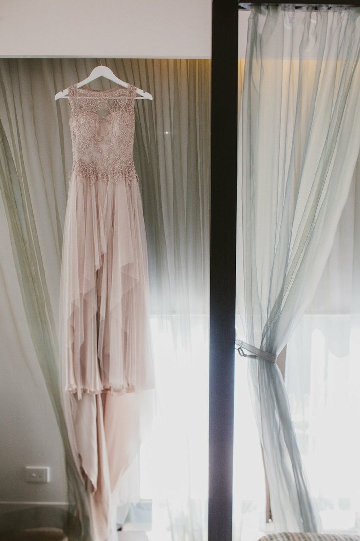 A gorgeous mauve wedding dress with a lace embellished bodice, no sleeves and a layered skirt