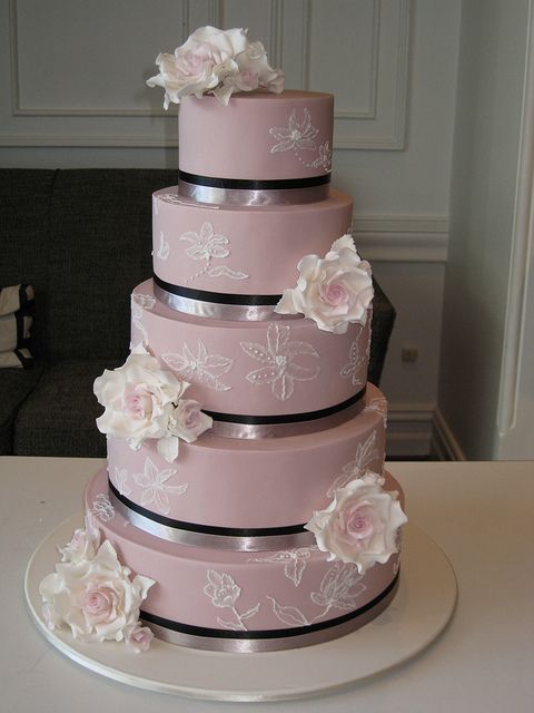 a large mauve wedding cake with white sugar blooms and ribbons is a stylish and tender wedding idea