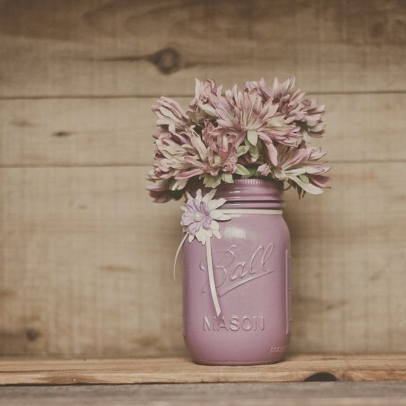 A mauve colored mason jar with pink and mauve blooms can be a wedding centerpiece or just a decoration