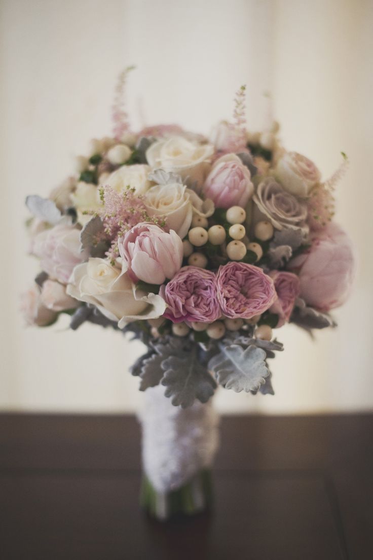 A delicate and soft wedding bouquet with mauve, ivory and blush blooms and berries