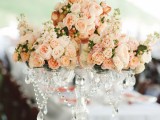 a refined wedding centerpiece of crystal, with blush and light pink blooms, berries and greenery is a very exquisite idea