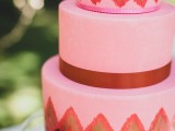 a pink wedding cake with burgundy ribbons and bright ikat patterns plus fresh blooms for detailing