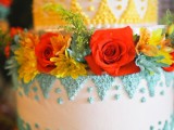 a bright yellow and green wedding cake with patterns and bright blooms and greenery for a colorful wedding