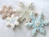 snowflake-shaped cookies with blue and white icing are amazing to embrace the season, they can also be nice wedding favors
