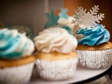 cupcakes with white and blue icing and snowflakes on top are amazing to give a wintry feel to your dessert table