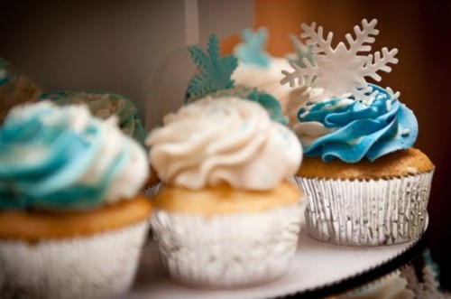 cupcakes with white and blue icing and snowflakes on top are amazing to give a wintry feel to your dessert table