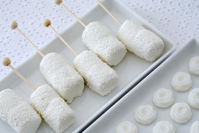 sparkling white marshmallow pops and white pavlovas will give a frozen fele to your winter wedding dessert table