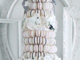 a refined alternative to a usual wedding cake – a black and white macaron tower, topped with black and white bows and ribbons and blooms