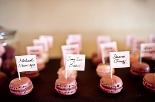 tiny pink macarons topped with names are a creative wedding seating chart for any wedding, they will tell your guests where to go in a tasty way