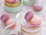 a pink and gold round box with pink and lilac macarons is a lovely idea of a wedding favor for any wedding