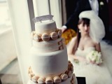 a white buttercream wedding cake decorated with neutral macarons is a creative and interesting idea for a wedding
