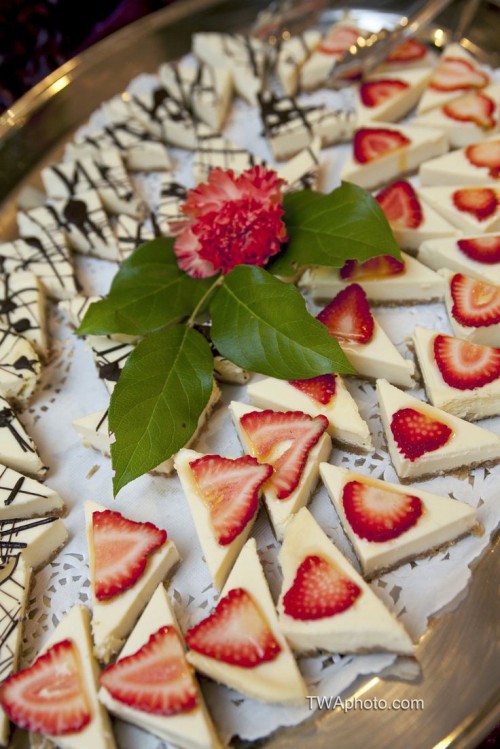 mini triangle cheesecakes with fresh strawberries on top and with chocolate patterns on top