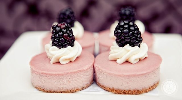 Mini pink cheesecakes with cream and blackberries on top for a fall or summer wedding