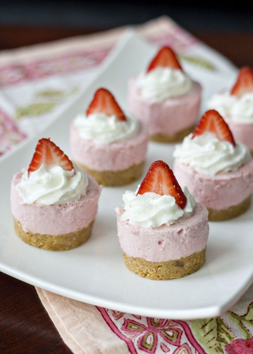 mini pink strawberry cheesecakes with cream and fresh berries on top are a timeless and tasty idea