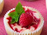 mini raspberry swirl cheesecakes with fresh berries and leaves on top are super tasty