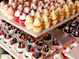 tasty cupcakes with whipped cream and fresh berries and mini cheesecakes with fresh blueberries, blackberries and raspberries