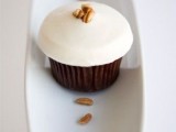 mini chocolate cupcakes with icing on top and walnuts are a refined and unique dessert idea