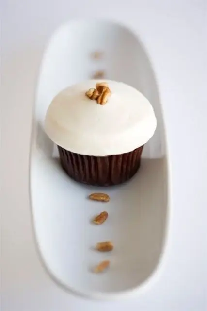 mini chocolate cupcakes with icing on top and walnuts are a refined and unique dessert idea