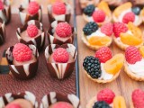 mini chocolate cups with chocolate cream and fresh raspberries on top and mini tartlets with whipped cream, fresh raspberries and blackberries plus fruit