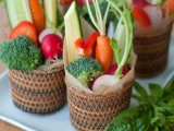 woven baskets with fresh veggies – horse radish, carrots, tomatoes, cucumbers and broccoli, perfect for a vegetarian wedding