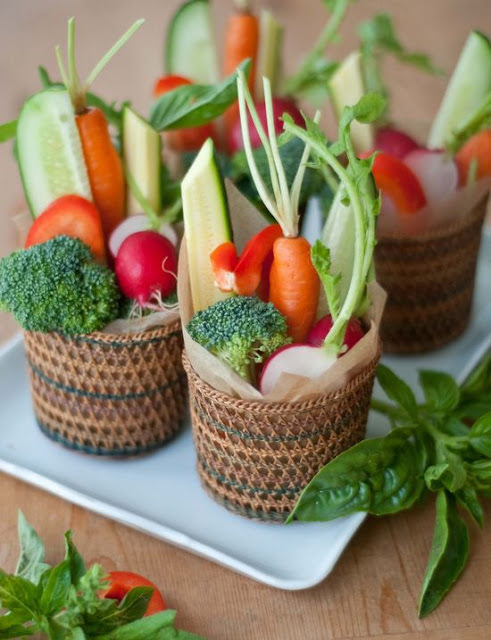 woven baskets with fresh veggies - horse radish, carrots, tomatoes, cucumbers and broccoli, perfect for a vegetarian wedding