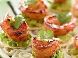 crackers with avocado drip, grilled shrimps and herbs on top is a refined idea