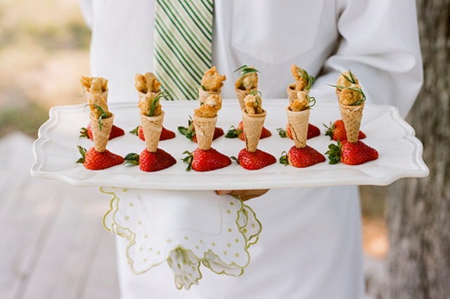 fried chicken in ice cream cones placed into strawberries looks very unusual