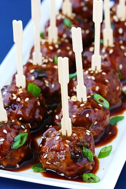 spiced meat balls spruced up with spring onions and sesame seeds on skewers are a timeless idea
