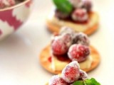 crackers with cheese, sugared cranberries and herbs on top as a delicious appetizer for summer and fall weddings