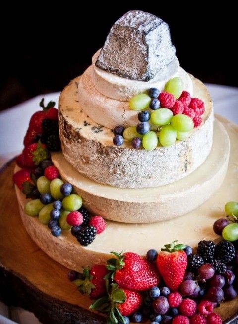 a cheese wheel tower topped with berries and fruit is a lovely idea for a vineyard wedding, it's an alternative to a traditional sweet wedding cake
