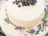 a white buttercream wedding cake topped with lavender and grapes is a lovely idea for a modern vineyard wedding that hints on the vineyard with its decor