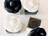 boxes with black and white fabric blooms on top for wedding favors