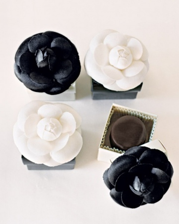 Boxes with black and white fabric blooms on top for wedding favors