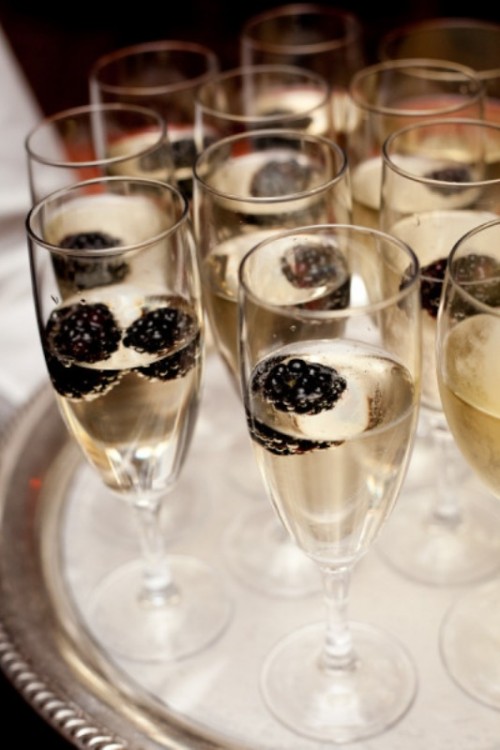 sparkly wine plus blackberries is a cool idea of a signature drink for your wedding