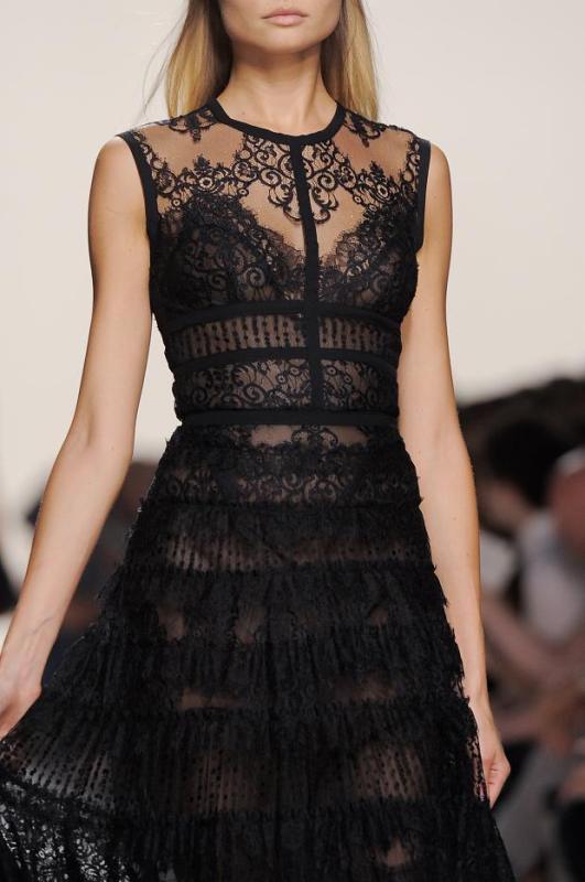 A semi sheer fitting black lace wedding dress with an illusion neckline, no sleeves