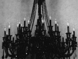 a bold black chandelier with bulbs is a gorgeous idea for a soft gothic wedding