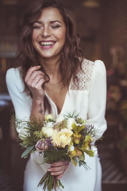 a pale wedding bouquet in white, lilac and green, with evergreens and usual greenery for a winter boho bride
