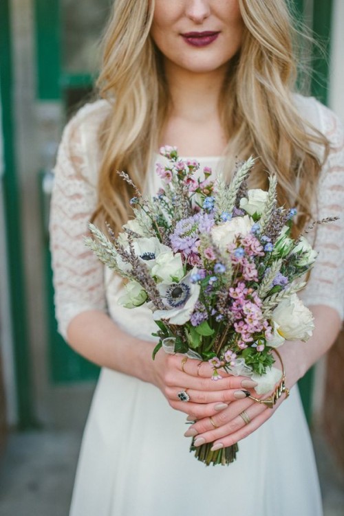 a pastel wedding bouquet of white and pastel blooms, of spikes and dried herbs,, with greenery