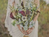 a spring wedding bouquet of pale greenery, purple blooms, lotus, white blooms is great for a touch of boho