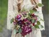 a bright summer boho wedding bouquet in purple, pink, white, with various kinds of blooms and greenery