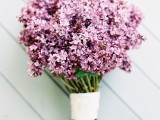 a lilac wedding bouquet with a white wrap is a simple and cool idea for a summer boho bride