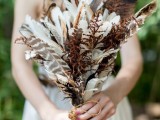 a boho wedding bouquet of feathers and dried elements is a cool idea for a fall boho bride