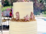 a yellow textural beach wedding cake with beach sand, starfish, sea horses and other edible stuff
