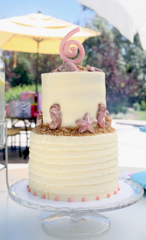 a yellow textural beach wedding cake with beach sand, starfish, sea horses and other edible stuff