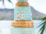 a bright beach wedding cake with light blue and tan tiers, bubbles, starfish, corals and other stuff for a creative and whimsy look