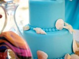 a bright blue wedding cake with seashells, real and sugar ones is all you need for a beach wedding